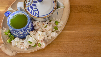 Vintage ceramic teapot and a blue ceramic tea with matcha green tea for morning breakfast, enjoying time, relax. Self care and simple things beauty concept.