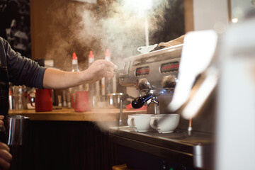 Barista making coffee using a coffee machine, hospitality and hot beverage concept.