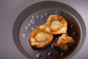 Deep fried crispy and golden dumplings in beef  stock