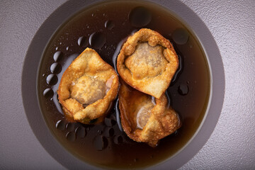 Deep fried crispy and golden dumplings in beef  stock