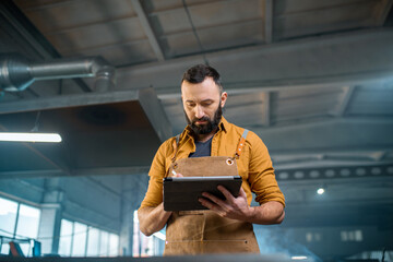 Metal industry worker with a digital tablet at the plant