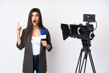 Reporter woman holding a microphone and reporting news over isolated white background pointing with the index finger a great idea