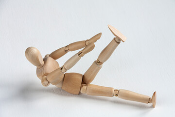 a wooden mannequin doing exercises on white background