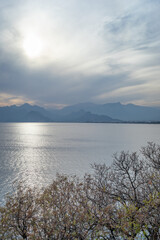 View from coast of port of old park Karaalioglu Antalya to opposite coast Beydajlari mountain range and sea. Sky in haze.