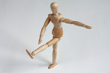 a wooden mannequin doing exercises on white background