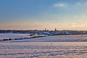 Fototapeta premium the catholic and protestant church of homberg in winter with snow and blue sky 