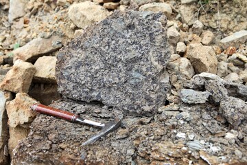 Geologists hammer on the phosphorite rock - Geological Fieldwork. geologist's hammer, rock hammer,...