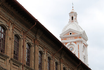 Ancient colonial palace with the bell tower of the San Francisco of Cuenca behind it