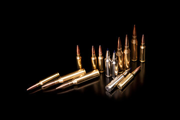 Bullet isolated on black background with reflexion. Rifle bullets close-up on black back....