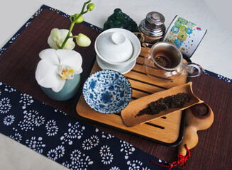 Fototapeta na wymiar Tea set and white orchid. Candid.