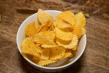 A bowl of chips or chips on a wooden table