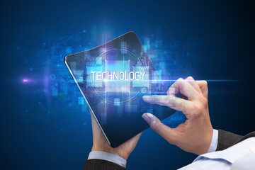 Businessman holding a foldable smartphone with TECHNOLOGY inscription, new technology concept