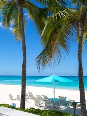 Crédence de cuisine en verre imprimé Plage de Seven Mile, Grand Cayman Grand Cayman Beach Deck Chairs Blue Umbrellas On Water's Edge.Caribbean, Grand Cayman, Seven Mile Beach, Cayman Islands, Palm Trees. Empty beach, No tourists