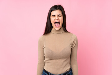 Young woman over isolated pink background shouting to the front with mouth wide open