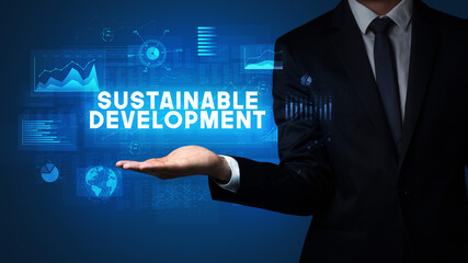 Hand of Businessman holding SUSTAINABLE DEVELOPMENT inscription, business success concept