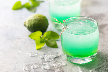 glass of cold drink with fresh mint leaves and ice cubes