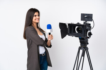 Reporter woman holding a microphone and reporting news over isolated white background looking to the side