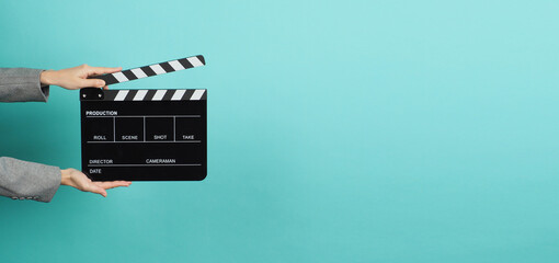 Black Clapperboard or movie Clapper board for videography with hands in grey suit. it use in video...