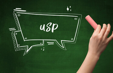 Hand drawing USP abbreviation with white chalk on blackboard