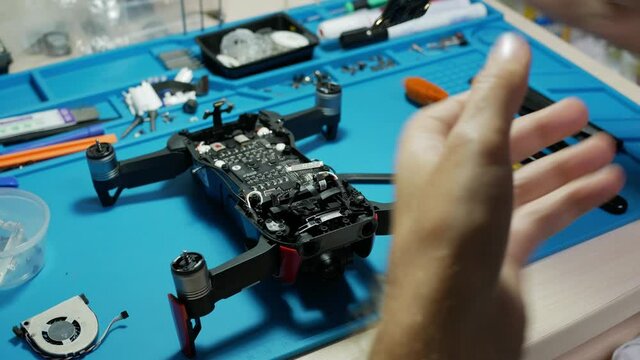 drone repair service. repairman disassembles the drone and removes the circuit board