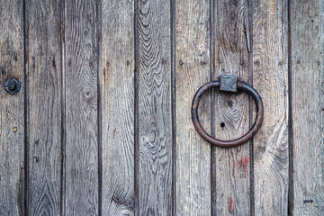 old wooden door with lock,  fragment of a vintage wooden door with an iron ring, cracks and...