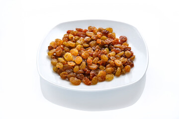 Dried sweet golden raisins in a white plate on an isolate on a white background copy space.