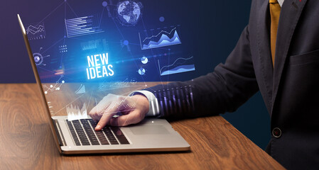 Businessman working on laptop with NEW IDEAS inscription, new business concept