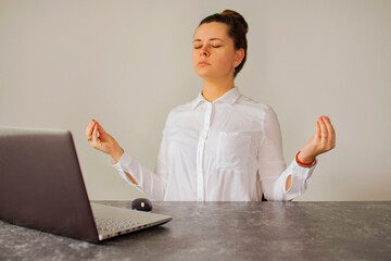 Office worker meditates in front of the computer