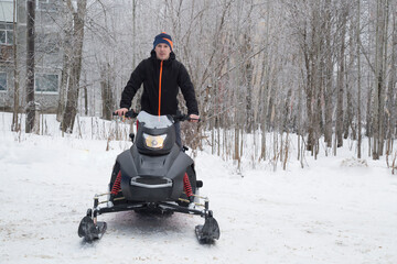 A man on a snowmobile. Equipment for driving through snow in winter.