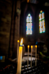 Candles burning in the foreground inside an old church in Spain. Religion, old architecture, Christianity, travel, concept of belief..