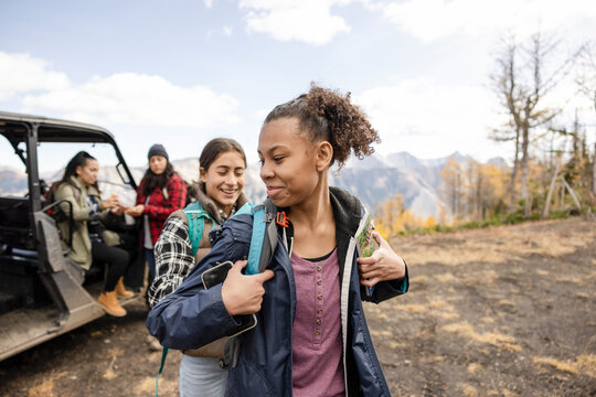 Teenage girls preparing for hike with m others on autumn mountain