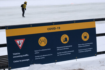 Covid 19 sign requesting distance and masks at all time on Rideau Canal skating path in Ottawa,...
