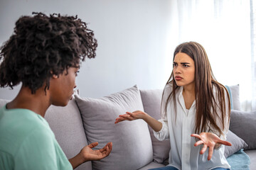 Two female friends sitting on sofa and arguing with each other. Friendship, quarrel, female...