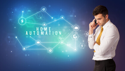 Businessman in front of cloud service icons with HOME AUTOMATION inscription, modern technology concept