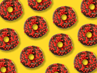Flat lay donuts in chocolate glaze pattern on a yellow background. Top view