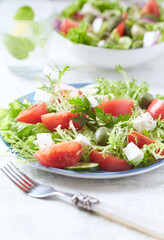 Salad with Green Olives, Tomatoes and Feta Cheese. Bright wooden background. Copy space.	