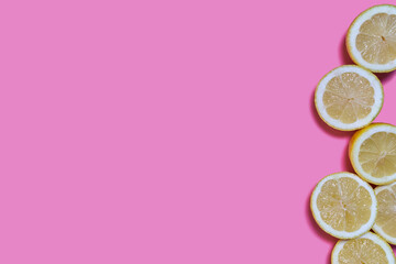 Lemon slices on a pink background. CITRUS CITRIC
