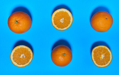 Whole and split oranges on a blue background. CITRUS CITRIC