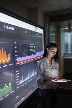 Businesswoman With Digital Tablet Working At Screen In Dark Office