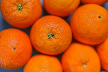 Oranges with skin seen close up on gray background. CITRUS CITRIC