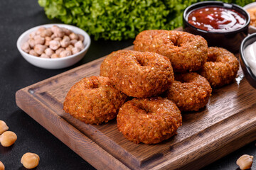 Beautiful delicious fresh chickpea falafel with sauces on a concrete background