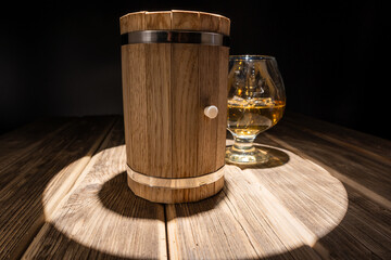 mini oak barrel for making homemade whiskey, and a glass with ice.