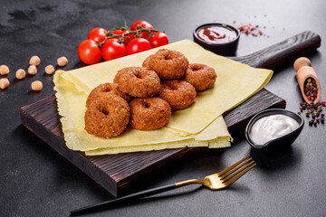 Beautiful delicious fresh chickpea falafel with sauces on a concrete background