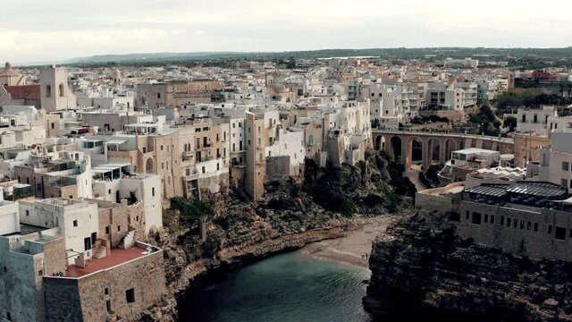 Aerial view on an ancient city coast with beach in Italy.