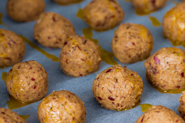 Falafel roh in Reihe auf einem Backpapier mit Öl