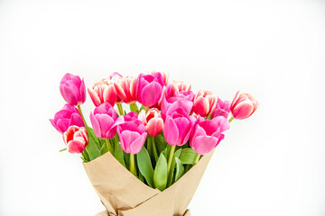 Bouquet of spring pink tulips wrapped in paper for a gift isolated on a white background