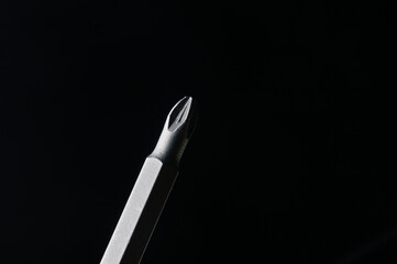 cross-shaped bit for a screwdriver on a black background. close-up.