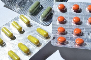 multi-colored tablets in foil blisters lie on a light background. close-up.