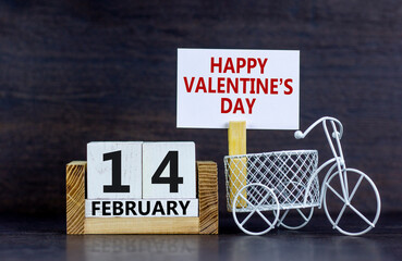 February 14 valentines day symbol. White paper with words 'Happy valentines day'. Miniature bicycle. Calendar with the date February 14. Beautiful grey background, copy space. Valentines day concept.