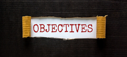 Objectives symbol. The word 'objectives' appearing behind torn black paper. Beautiful background. Business and objectives concept.